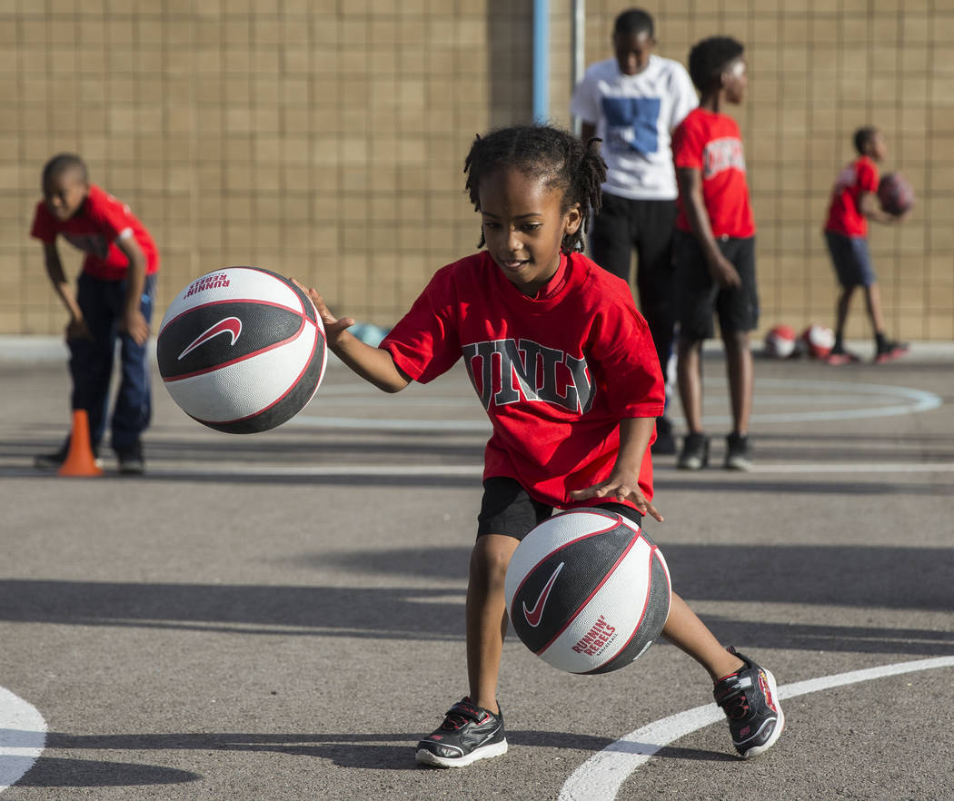 Jayceon Jackson, 6, practices dribbling two basketballs during a youth clinic hosted by UNLV he ...