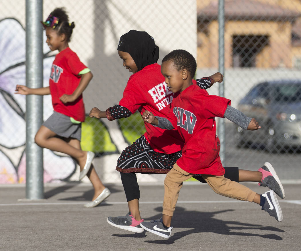 Fardosa Blial, center, 6, races Ryan Fraley, right, 4, during a youth clinic hosted by UNLV hea ...