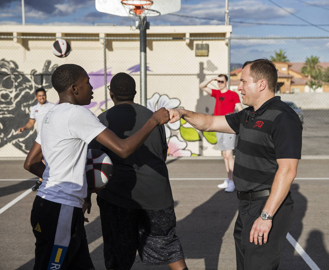 UNLV head basketball coach T.J. Otzelberger, right, pounds it out with Isaiah Taylor during a y ...