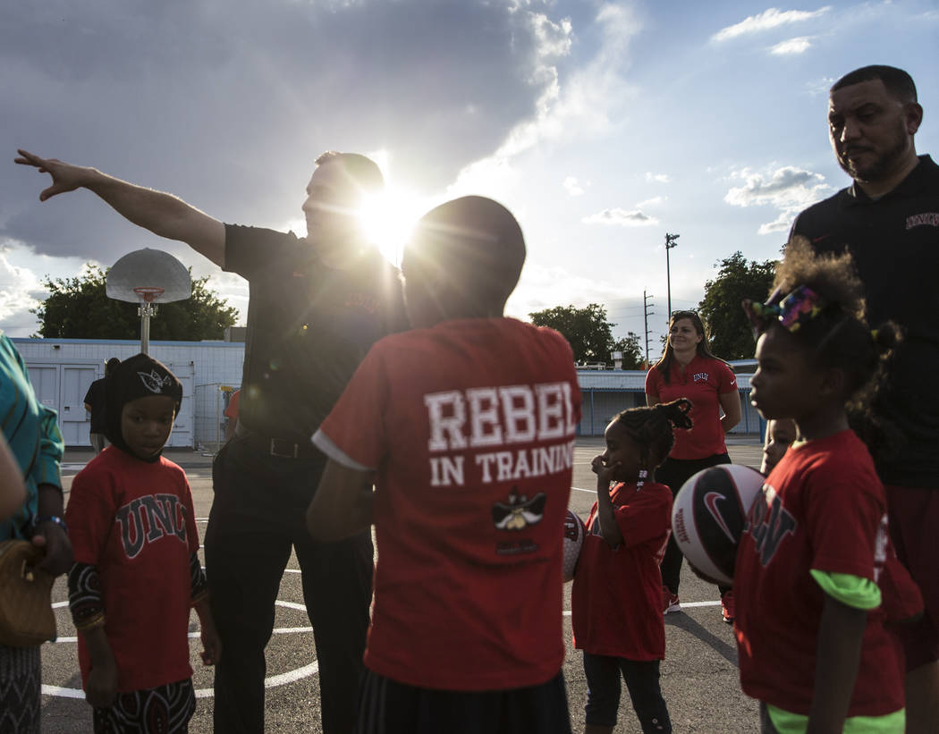 UNLV head basketball coach T.J. Otzelberger, top/left, directs kids during a youth clinic at th ...