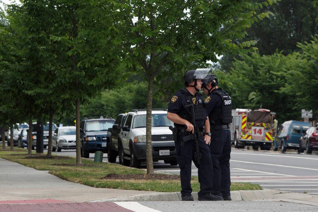 Virginia Beach Police Officers huddle near the intersection of Princess Anne Road and Nimmo Par ...