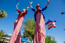 Patriotic stilt walkers wave to crowds during the Summerlin Council Patriotic Parade in Summerl ...