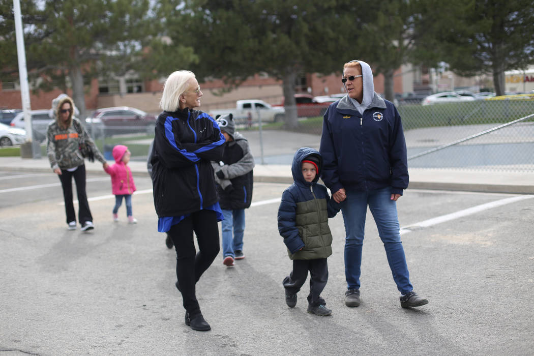 Jennifer Hood speaks to April Carlson and her grandson Bentley Brown, 4, as they walk to a park ...