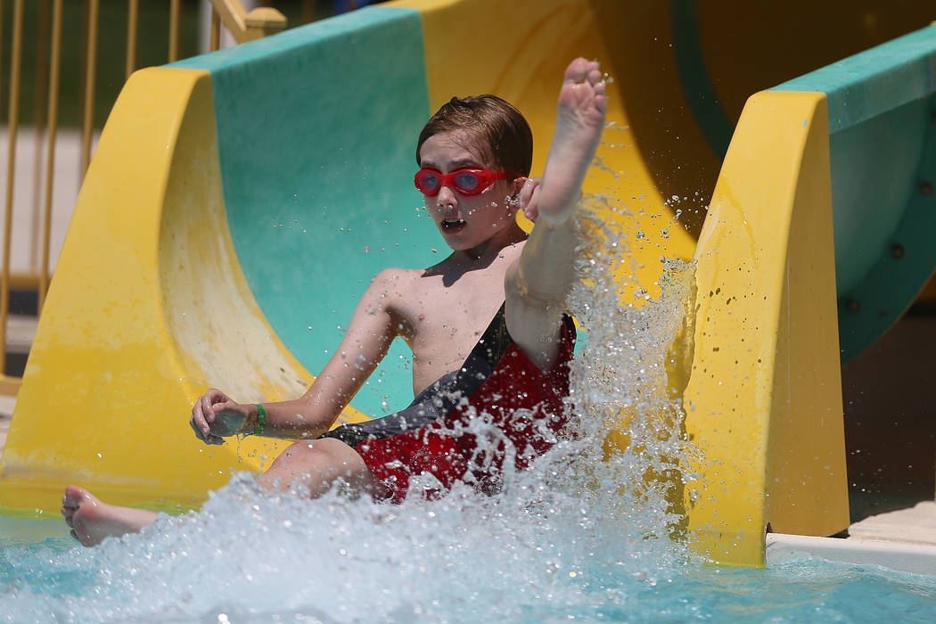 Mason Schriever, 13, slides down the water slide during the annual Ward 4 Summer Splash at the ...