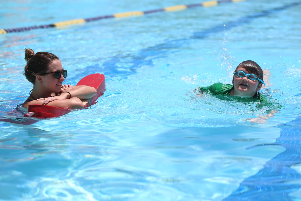 Conor Staniecki, 10, right, swims as lifeguard Abbie Hendricks keeps an eye on him during the a ...