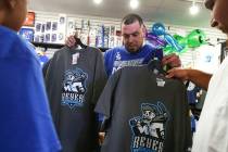 Jesus Gonzalez, center, checks out shirts featuring the special Las Vegas 51s "Reyes de Plata" ...