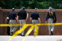 Law enforcement officials walk down a ramp to enter a municipal building that was the scene of ...