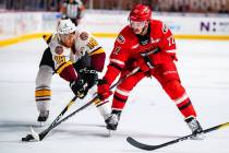 Chicago Wolves center T.J. Tynan (18) battles Charlotte Checkers right wing Andrew Poturalski f ...