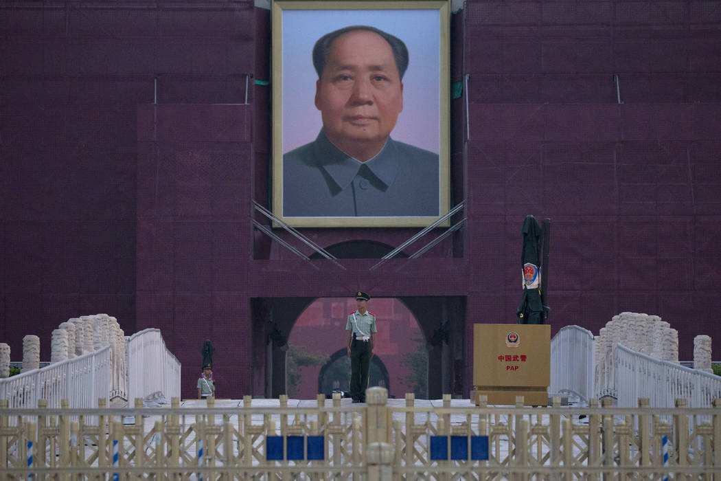 A Chinese paramilitary policeman stands guard in front of Mao Zedong's portrait on Tiananmen Ga ...