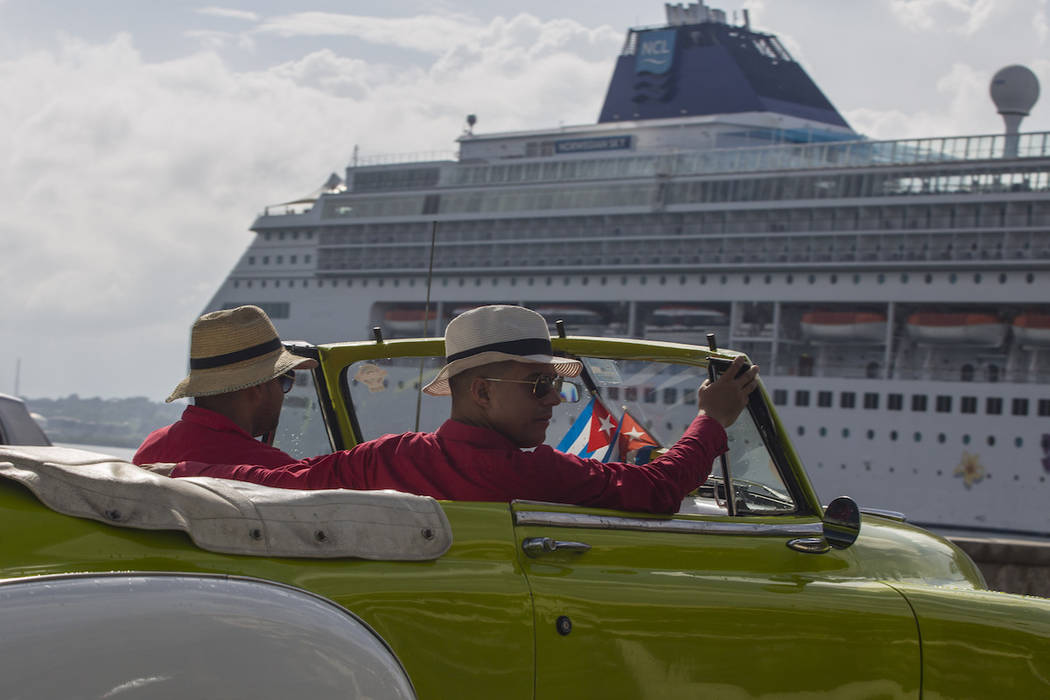 Local tour guides look for customers in their convertible car near a cruise ship docked in Hava ...