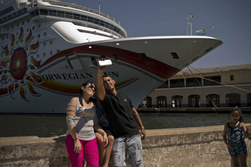 Cubans take a selfie in front of a cruise ship docked in Havana, Cuba, Wednesday, April 17, 201 ...