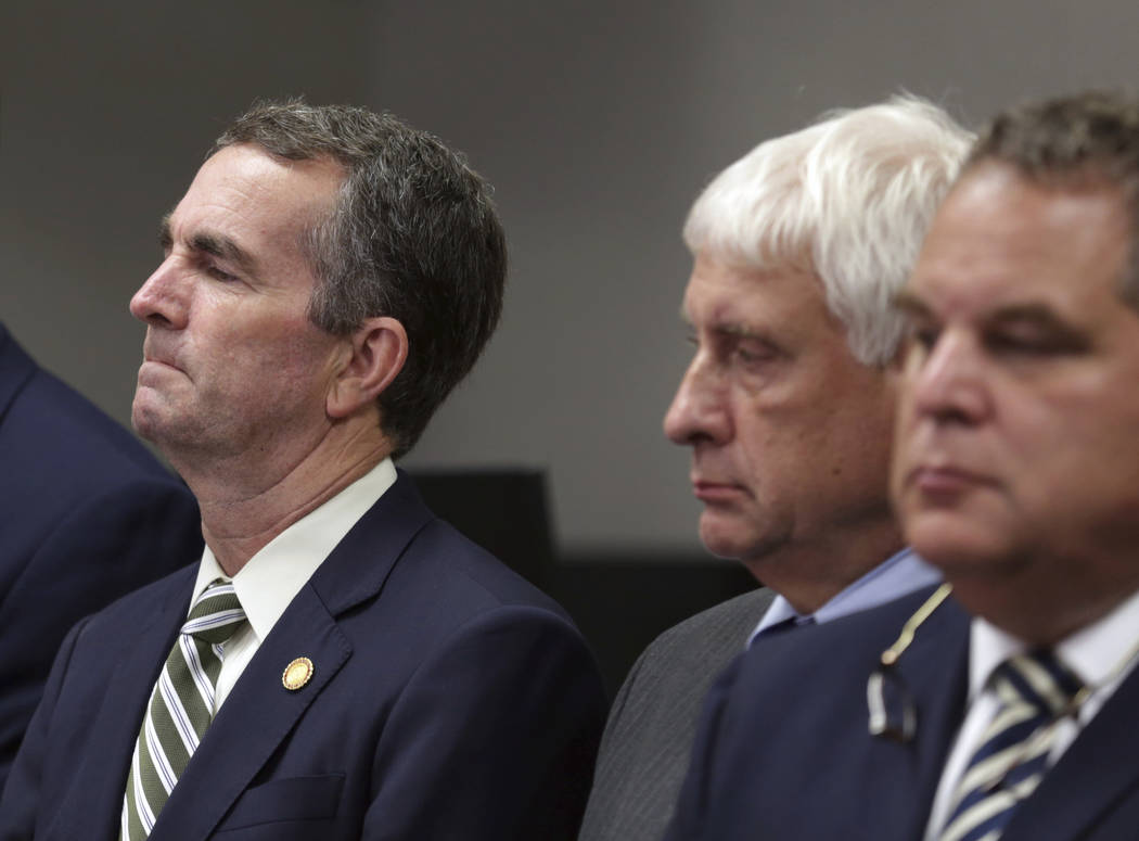 Virginia Gov/ Ralph Northam, left, listens during a news conference in Virginia Beach, Va. Frid ...