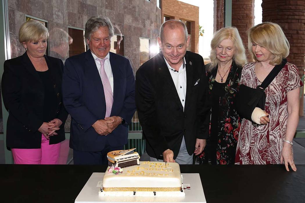 Jonathan Warren, chairman and CEO the Liberace Foundation, center, cuts Liberace's birthday cak ...