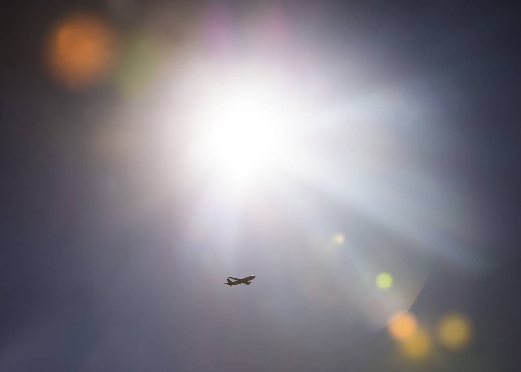 A plane leaving from McCarran International Airport passes by the sun on Wednesday, June, 5, 20 ...