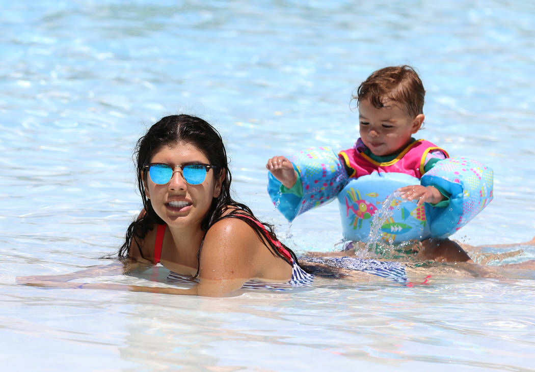 Beatriz Park of Henderson and her daughter Emilia, 2, cool off as they play in the Surf-A-Rama ...