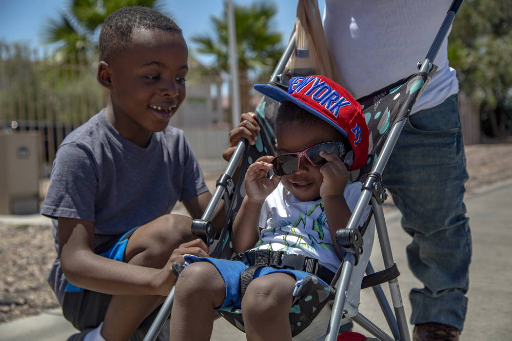 Jayvion Jackson, 2, right, of North Las Vegas, tries on sunglasses as his brother Jaiden, 5, lo ...