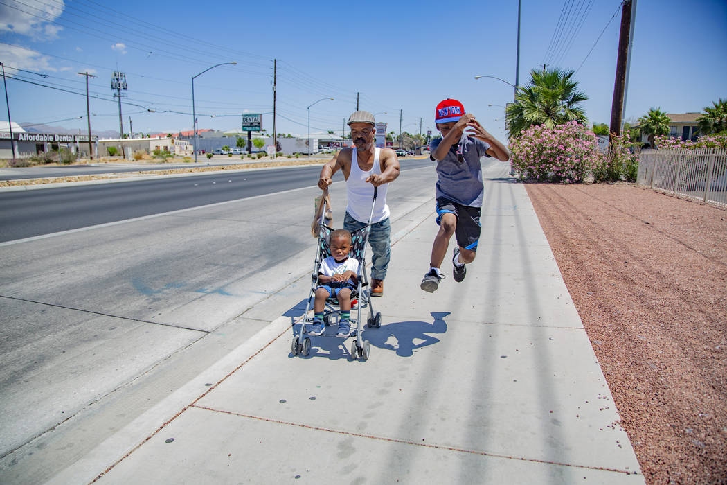 Emmanuel Worthington, 58, of North Las Vegas walks back home with his Grandchildren, Jaiden Jac ...