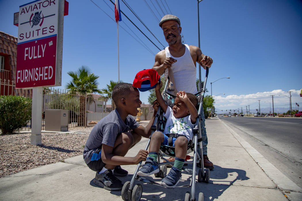 Jayvion Jackson, 2, right, of North Las Vegas takes a cap from his brother Jaiden, 5, while wal ...