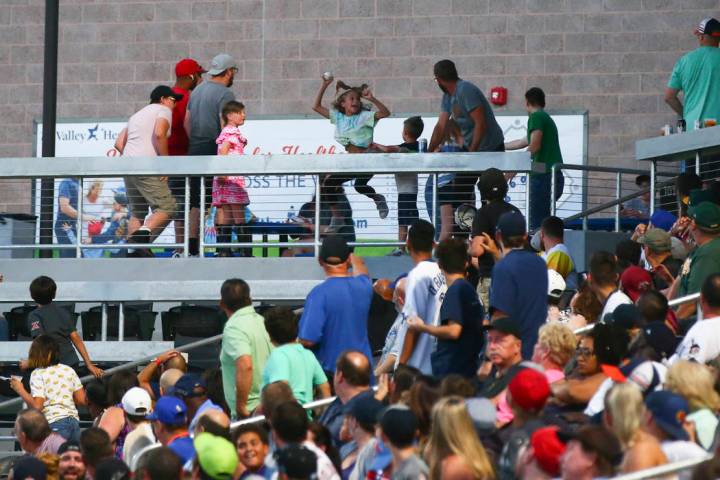 A young fan celebrates after catching a foul ball during the second inning of a baseball game b ...