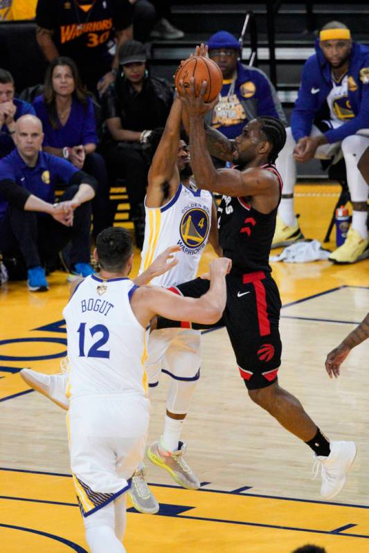 Toronto Raptors forward Kawhi Leonard, right, shoots against Golden State Warriors guard Quinn ...