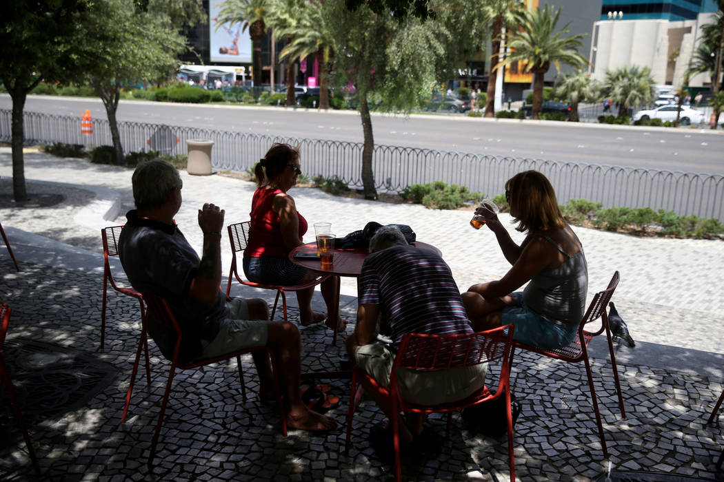 People, who declined to give their names, keep cool in the shade in front of Nine Fine Irishmen ...