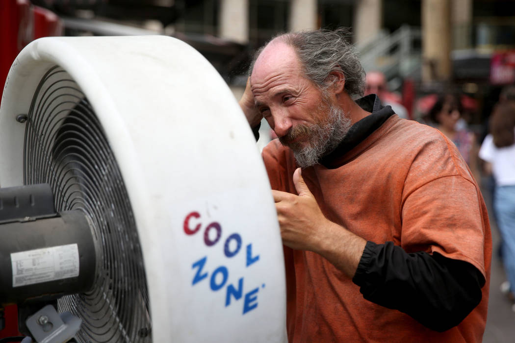 A man, who declined to give his name, keeps cool in on the Strip near Harmon Avenue in Las Vega ...