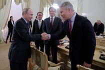 Russian President Vladimir Putin, left, shakes hands with Gary Pruitt, President and CEO of The ...