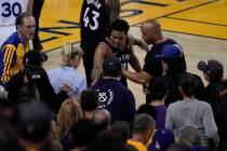 Toronto Raptors guard Kyle Lowry, middle, gestures next to referee Marc Davis (8) near the fron ...