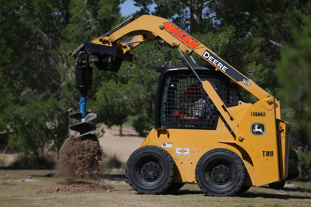 A worker digs a hole at the Aliante Golf Club in North Las Vegas, Thursday, June 6, 2019. (Erik ...