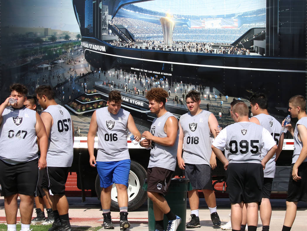 Clark County-area high school football players take a break as they participate in fundamental ...