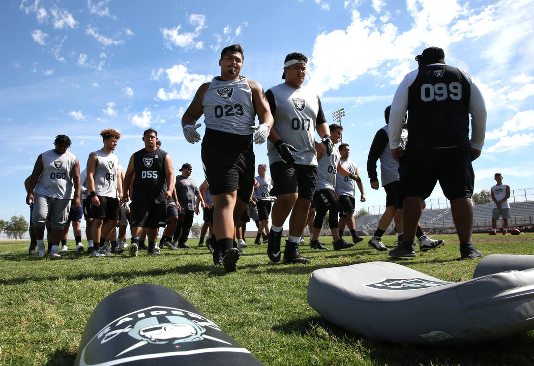 Former Faith Lutheran high school's offensive line coach De'Andre Nicholas, right, watches as C ...