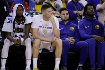 Golden State Warriors' Klay Thompson, second from right, sits on the bench with Alfonzo McKinni ...