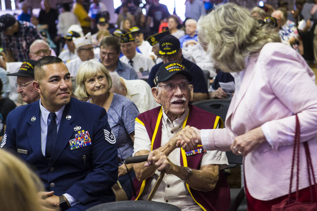 World War II veteran Dean Whitaker, 94, center, is greeted by U.S. Rep. Dina Titus, D-Nev., rig ...