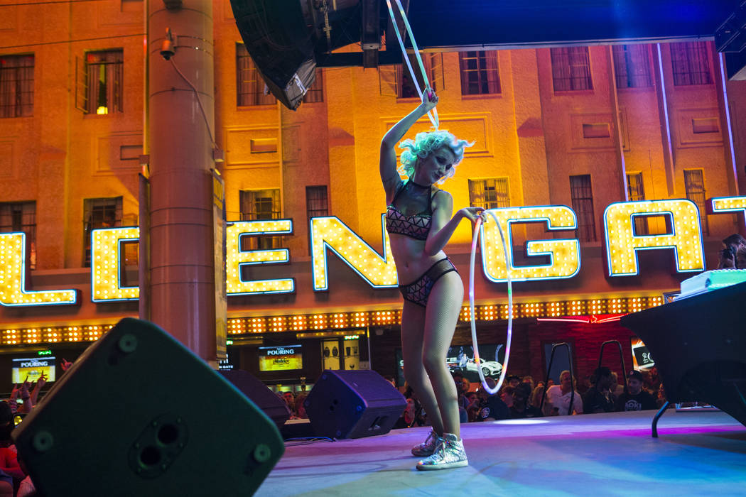 A dancer performs before an appearance by Steve Aoki at the Fremont Street Experience in downto ...