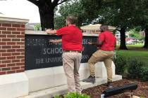University of Alabama employees remove the name of Hugh F. Culverhouse Jr. off the School of La ...