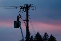 A Pacific Gas & Electric lineman works to repair a power line in fire-ravaged Paradise, Calif., ...