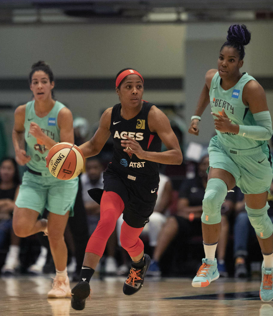 Las Vegas Aces' Sydney Colson, center, dribbles against the New York Liberty in the first quart ...