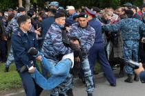 Kazakh police detain a demonstrator during an anti-government protest during the presidential e ...