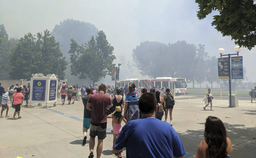 In this photo provided by Arthur Wilkie, people evacuate Six Flags Magic Mountain and Hurricane ...