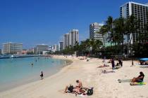 People relax on the beach in Waikiki in Honoluluin 2017. (AP Photo/Caleb Jones, File)