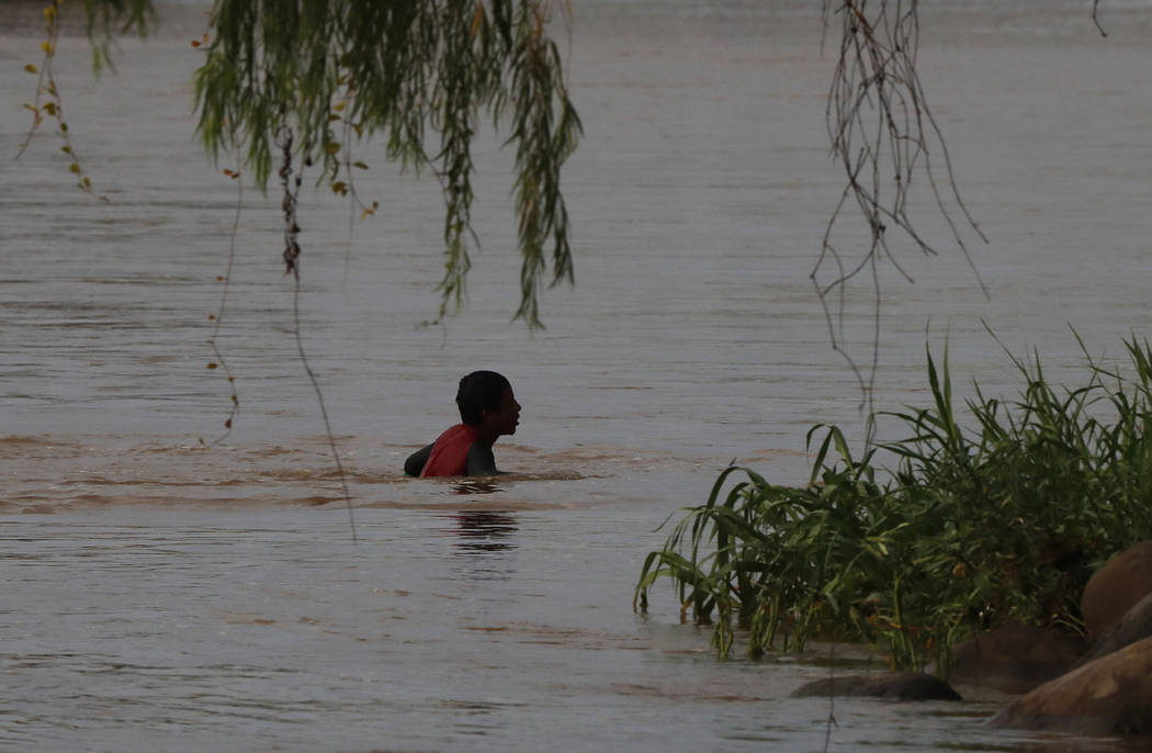 A migrant swims from Guatemala to Mexico across the Suchiate River near Ciudad Hidalgo, Mexico, ...