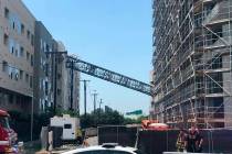 A photo taken and provided by Michael Santana shows a construction crane toppling on an apartme ...