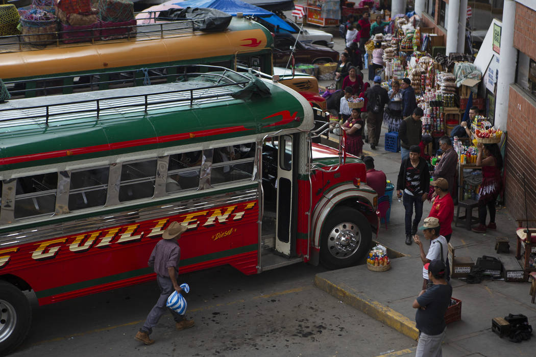 In this June 8, 2019, photo, people wait for a bus at the terminal in San Marcos, Guatemala. Th ...