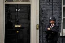 A police officer stands guard outside the door of 10 Downing Street in London, Friday, June 7, ...