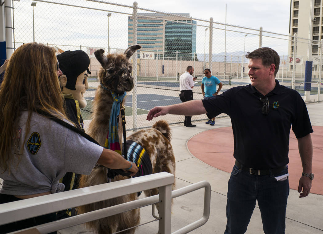 Brett Lashbrook, owner and CEO of Lights FC, greets a llama while preparing for the team's phot ...