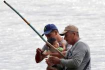 A migrant pays a man after he rafted him and his family across the Suchiate river from Guatemal ...
