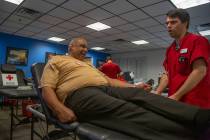 Mitchell Christensen, 28, from St. George, Utah, helps James Clark, 63, from St. Louis, left, ...