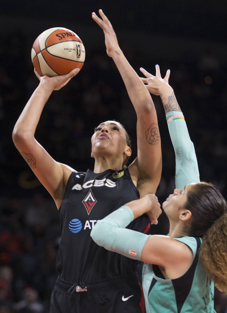 Las Vegas Aces center Liz Cambage (8) drives past New York Liberty center Amanda Zahui B. (17) ...