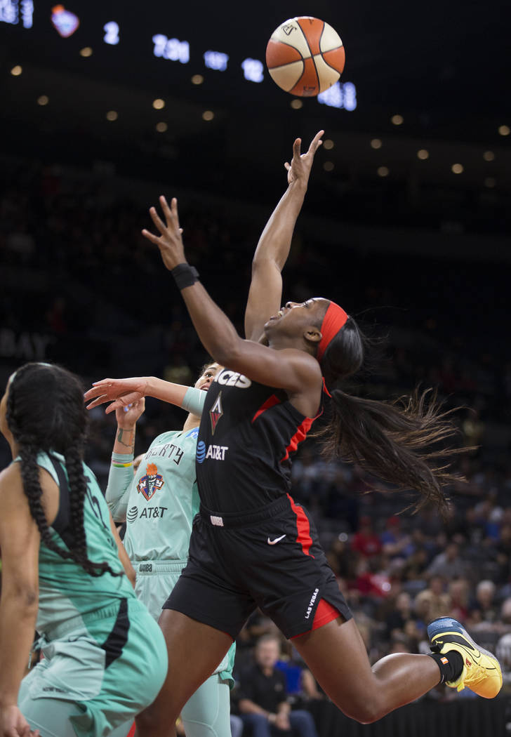 Las Vegas Aces guard Jackie Young (0) drives past New York Liberty guard Brittany Boyd (15) in ...