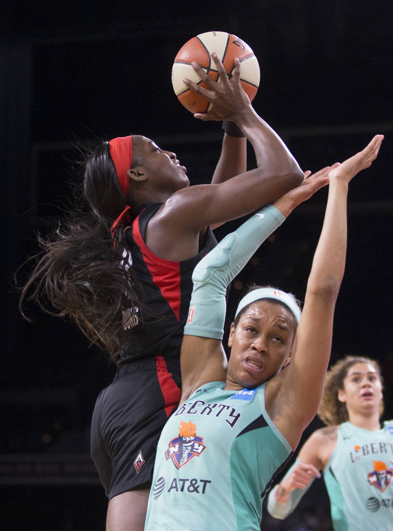 Las Vegas Aces guard Jackie Young (0) drives past New York Liberty guard Asia Durr (25) in the ...